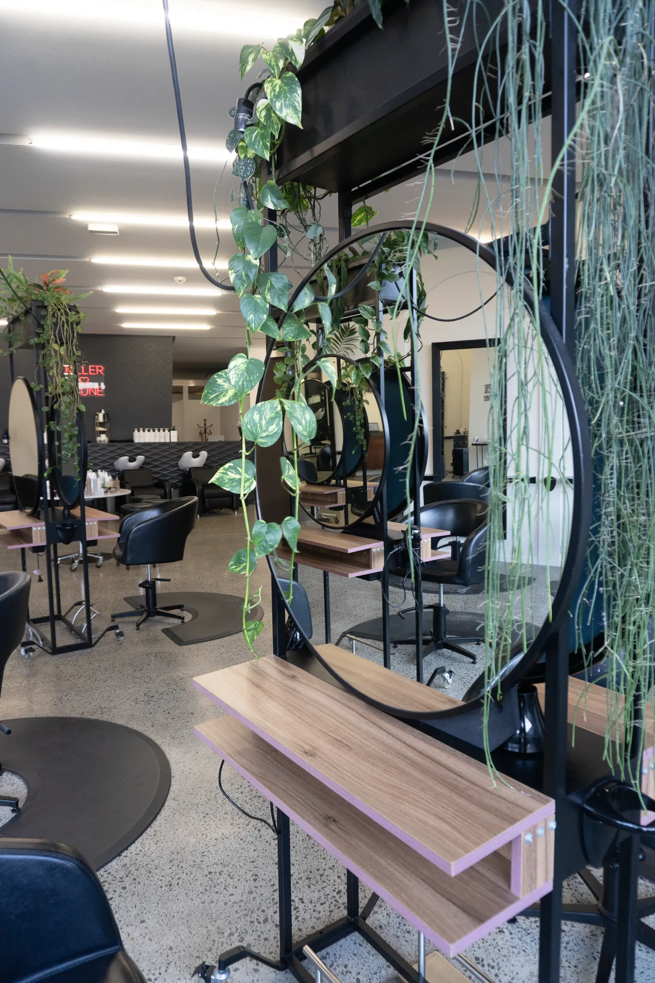 A round styling mirror framed by trailing greenery