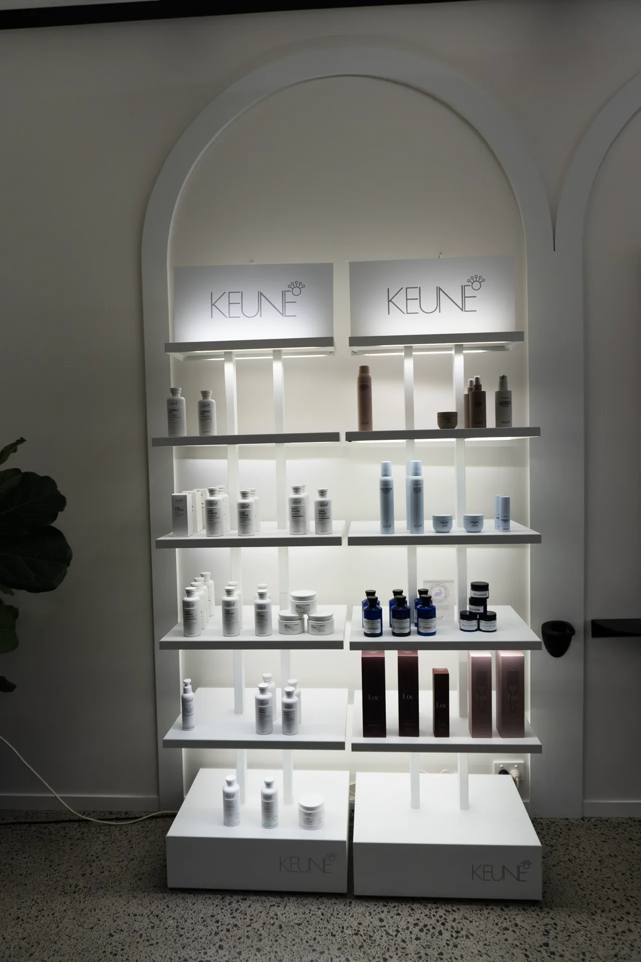 Keune products displayed within an arched wall alcove